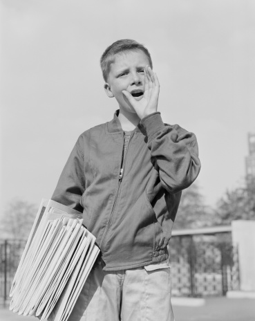 USA, New York, New York City, Paperboy (14-15) holding newspapers, shouting